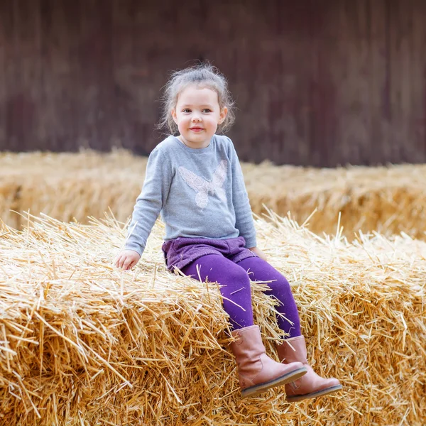 Šťastná dívka baví s seno na farmě — Stock fotografie