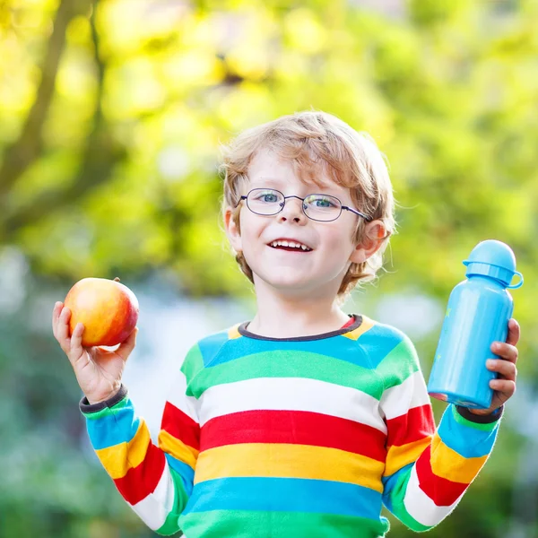 Kleiner Schuljunge mit Büchern, Apfel und Trinkflasche — Stockfoto