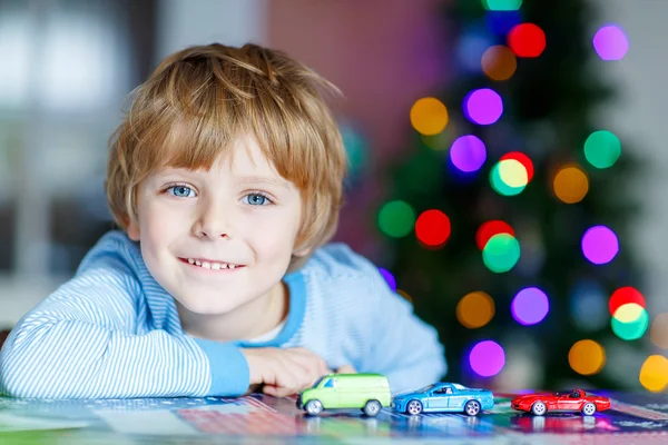 Маленька блондинка грає з машинами та іграшками вдома — стокове фото