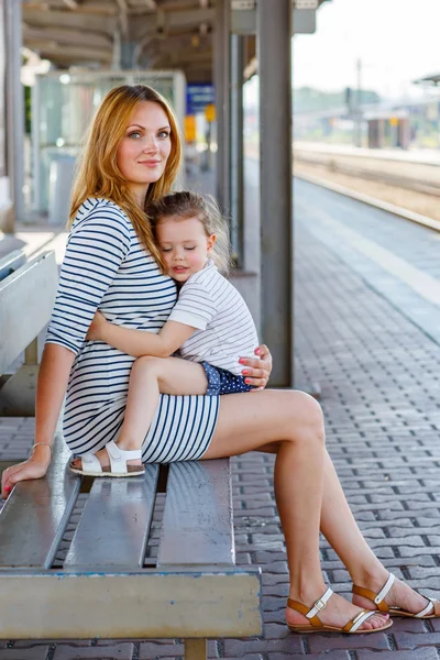 Roztomilá holčička a matka na železniční stanici. — Stock fotografie