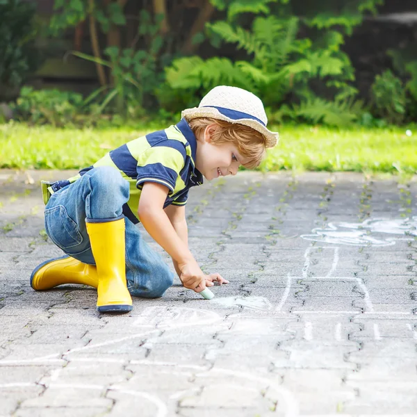 Menino pintando um veículo trator com giz no verão — Fotografia de Stock