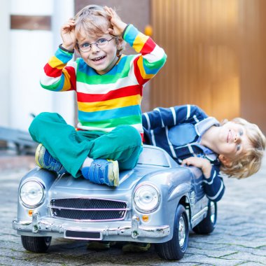 Büyük eski oyuncak araba yaz Bahçe, ou ile oynarken iki mutlu çocuk