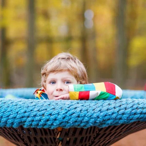 Liten unge pojke att ha kul på hösten lekplats — Stockfoto