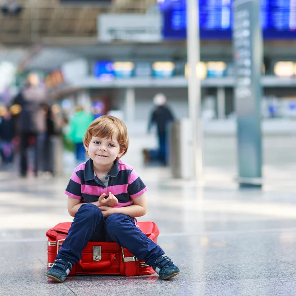 Mały chłopiec będzie na wyjazd wakacje walizka na lotnisku — Zdjęcie stockowe