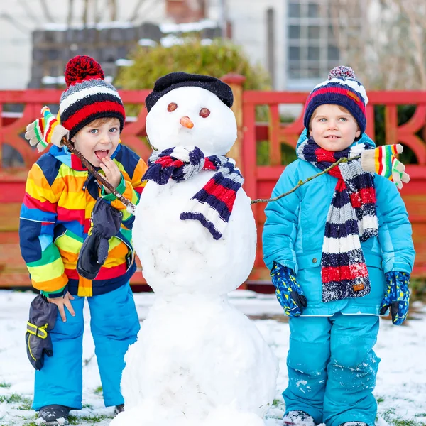 Twee kleine broers en zussen jongens maken een sneeuwpop, spelen en hebbend fu — Stockfoto