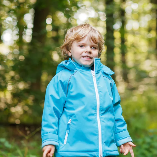 Portrait of blond little toddler  boy in blue waterproof raincoa — Stock Photo, Image