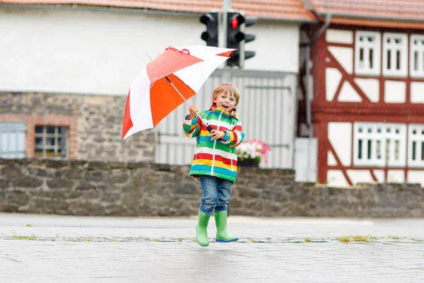 Malý blonďatý kluk kluk s velkým deštníkem venku — Stock fotografie