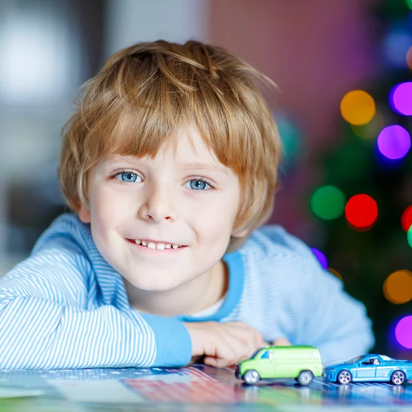 Μικρό ξανθό παιδί που παίζει με τα αυτοκίνητα και τα παιχνίδια στο σπίτι — Φωτογραφία Αρχείου