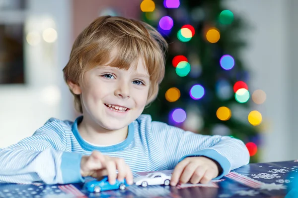 Little blond child playing with cars and toys at home — Stock Photo, Image