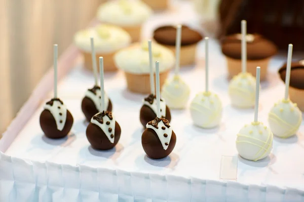 Pop dorty ke nevěsty a ženicha na svatební stůl sladké — Stock fotografie