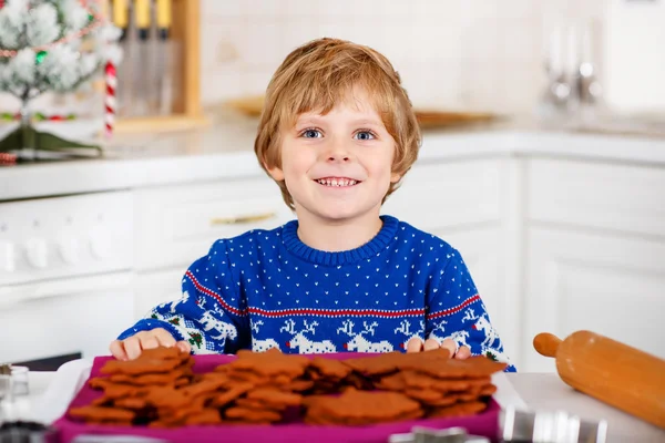 Маленький мальчик печет рождественское печенье дома — стоковое фото