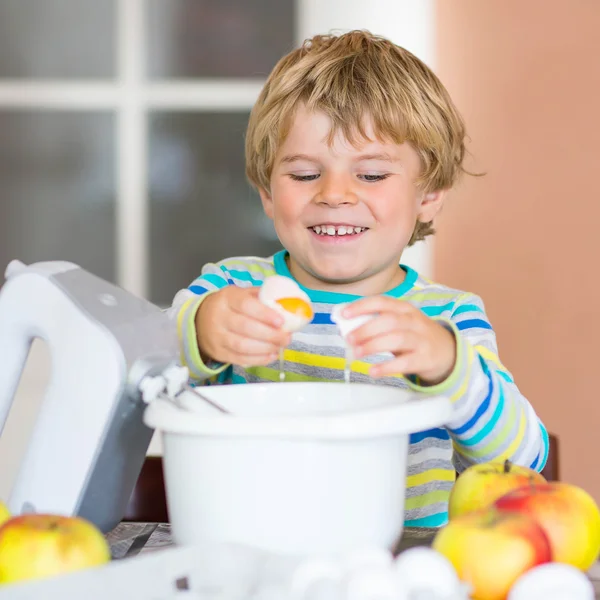 Divertido chico rubio hornear pastel de manzana en el interior — Foto de Stock