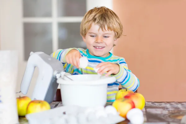 Zabawne dziecko blond chłopiec pieczenia ciasto jabłko pomieszczeniu — Zdjęcie stockowe