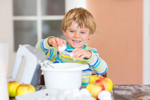 Divertente ragazzo biondo che cuoce torta di mele al chiuso — Foto Stock