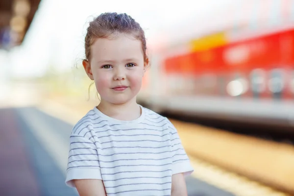 Schattig klein meisje op een treinstation. — Stockfoto