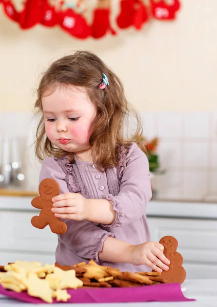 Kleines Mädchen backt Lebkuchen in der heimischen Küche — Stockfoto