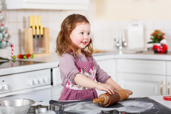 Malá holčička pečení perníku cookie v domácí kuchyni — Stock fotografie