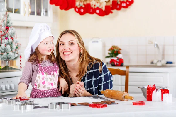 Matka a dítě holčička pečení perníku cookies pro Krista — Stock fotografie