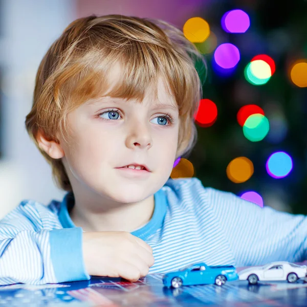 Little blond child playing with cars and toys at home — Stock Photo, Image