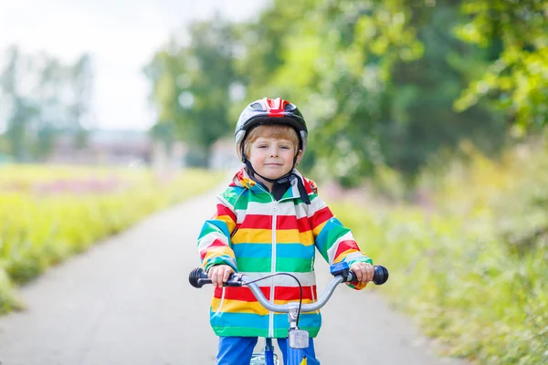 Kid jongen in helm met zijn eerste fiets, buitenshuis — Stockfoto