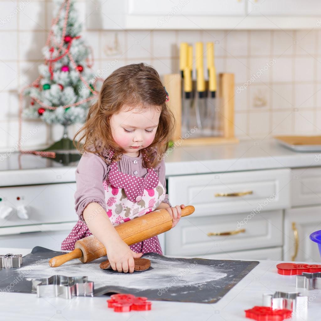 Little girl baking gingerbread cookies in domestic kitchen — Stock