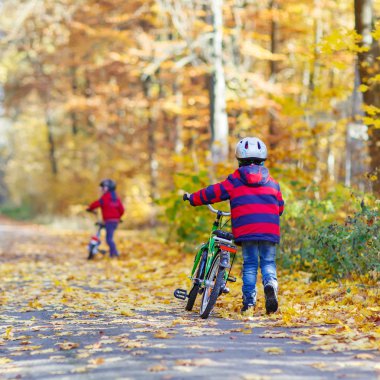 İki küçük çocuklar sonbahar ormandaki bisiklet ile çocuk