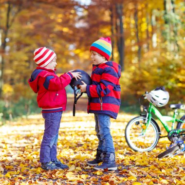İki küçük çocuklar sonbahar ormandaki bisiklet ile çocuk
