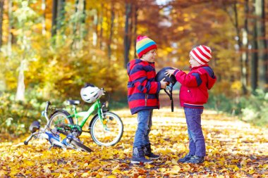 İki küçük çocuklar sonbahar ormandaki bisiklet ile çocuk
