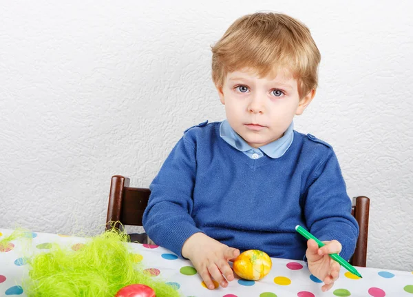 Kleine peuter jongen schilderij kleurrijke eieren voor Pasen jagen — Stockfoto