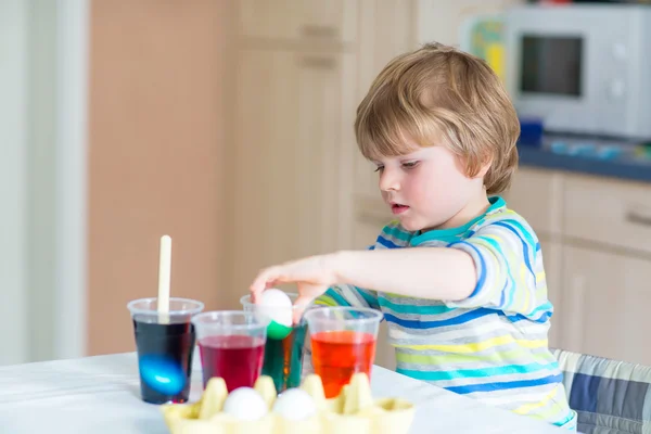 Kid jongetje kleuren eieren voor paasvakantie — Stockfoto