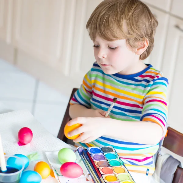 Kid jongetje kleuren eieren voor paasvakantie — Stockfoto