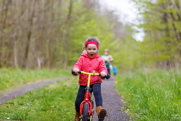 Kid girl riding his first bike, outdoors — ストック写真