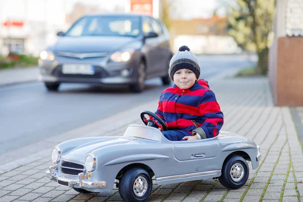 Little boy driving big toy car and having fun, outdoors — Stock Photo, Image