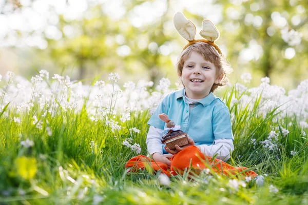 Paskalya bunny kulaklar giyen ve choco yeme şirin mutlu küçük çocuk — Stok fotoğraf