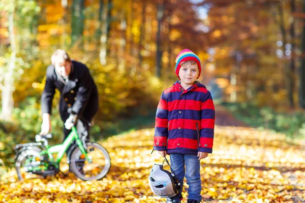 Niño y padre con bicicleta en el bosque otoñal — Foto de Stock