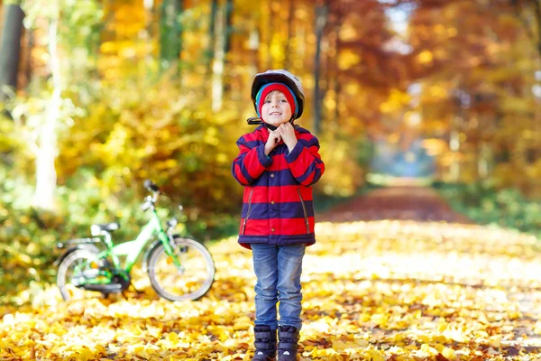 Menino com bicicleta na floresta de outono — Fotografia de Stock