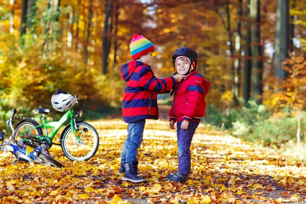 Dois garotos com bicicletas na floresta de outono — Fotografia de Stock