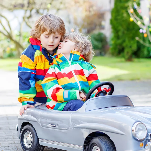 Dois meninos irmãos felizes brincando com o carro de brinquedo velho grande — Fotografia de Stock