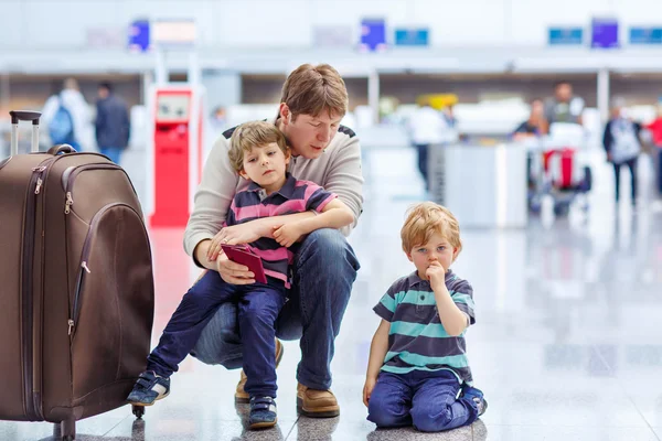 Отец и двое маленьких братьев и сестер в аэропорту — стоковое фото