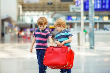 Two tired little sibling boys at the airport