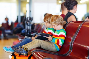Two tired little sibling boys at the airport