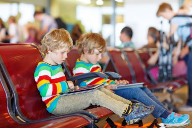 Two tired little sibling boys at the airport