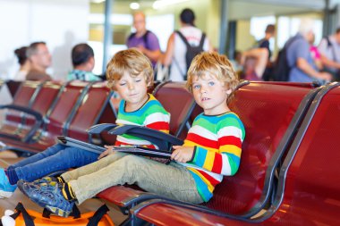 Two tired little sibling boys at the airport