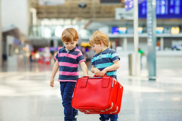 Two tired little sibling boys at the airport — Zdjęcie stockowe