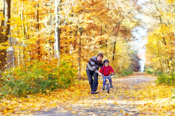 Little kid boy and father with bicycle in autumn forest — Stock Photo, Image