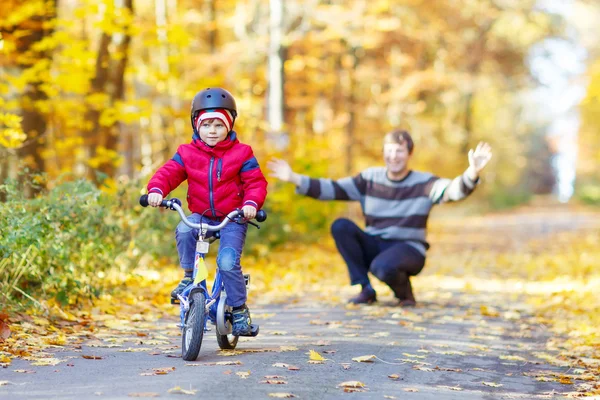 Kleine jongen jongen en vader met fiets in herfst bos — Stockfoto