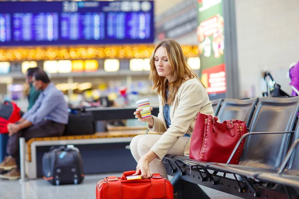Kvinna på internationella flygplats väntar flyg på terminal — Stockfoto