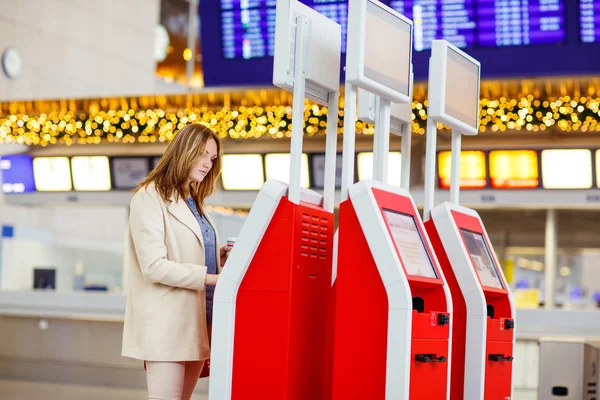 Kvinna på internationella flygplats väntar flyg på terminal — Stockfoto