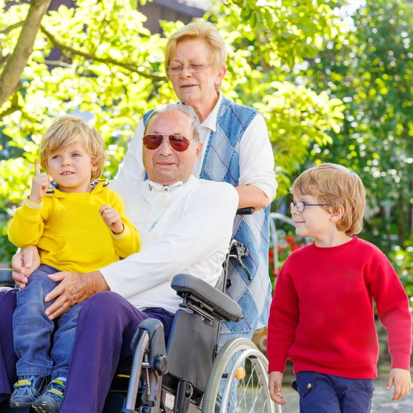 Two little kid boys, their grandmother and grandfather in wheelc — Φωτογραφία Αρχείου