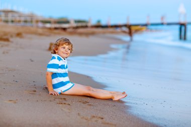 Mutlu küçük çocuk çocuk Kumdan kale ile okyanus ile eğlenmek
